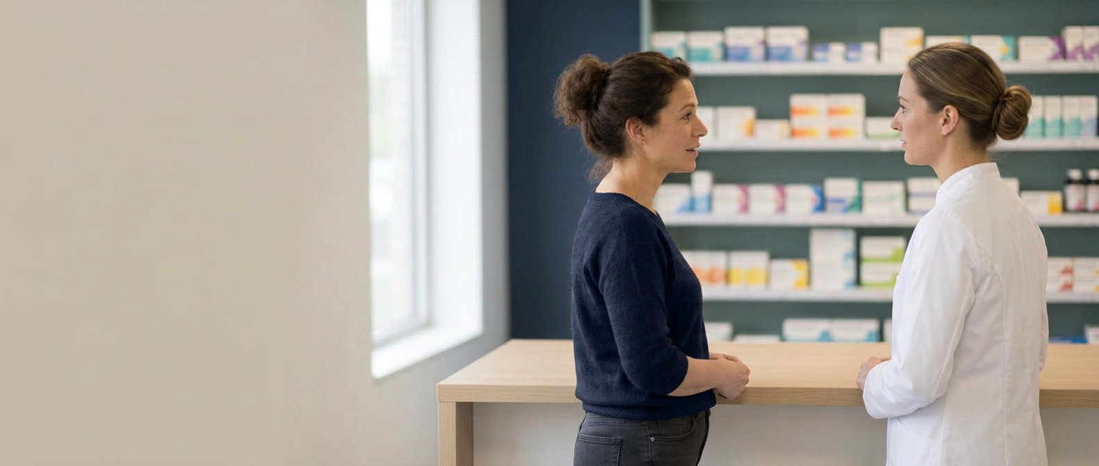 Auditor en apothekersassistente in gesprek achter de balie